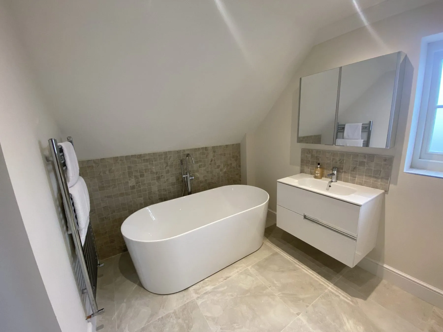 A gleaming bathroom with a freestanding bath and walk-in shower, ready for the next guests